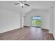 Open-concept living room with wood-look floors, ceiling fan and access to a large lawn at 2674 Sw 165Th Street Rd, Ocala, FL 34473