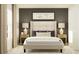 Contemporary bedroom with gray accent wall, plush bed with decorative pillows and bedside tables with lamps at 2934 Pennachio Dr, Lake Wales, FL 33859