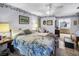 Cozy bedroom featuring floral accents, a ceiling fan, and an adjoining bathroom at 105 Country Club Ln, Mulberry, FL 33860