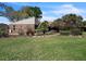 Charming brick home featuring a well-maintained lawn and beautiful landscaping with various plants and trees at 105 Country Club Ln, Mulberry, FL 33860