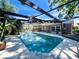 Relaxing screened-in pool with brick surround, lush landscaping and space for entertaining at 105 Country Club Ln, Mulberry, FL 33860