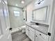 Bathroom featuring marble tiled shower and white vanity with illuminated mirror at 1390 Patricia St, Kissimmee, FL 34744