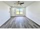 This bedroom features grey wood-style flooring, a ceiling fan, and a sun-filled window at 1390 Patricia St, Kissimmee, FL 34744