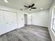 Neutral bedroom with vinyl floors, ceiling fan, and a window overlooking the backyard at 1390 Patricia St, Kissimmee, FL 34744