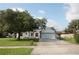 Charming single-story home featuring a well-manicured lawn, large trees, and a two-car garage at 250 Ashley Rd, Mascotte, FL 34753
