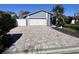 Paver driveway leading to the garage of this single-Gathering home with beautiful landscaping and an American Flag at 105 Ingram Cir, Longwood, FL 32779