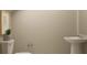 Minimalist bathroom featuring a pedestal sink, toilet, and neutral color scheme at 1807 Teagan Ln, Winter Haven, FL 33884