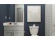 Modern bathroom with navy blue walls, white vanity, and shower with stylish decor at 2077 Lasso Loop, Eagle Lake, FL 33839