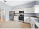 Bright kitchen with stainless steel appliances, granite countertops, and white cabinetry at 215 Maple Ln, Fort Meade, FL 33841