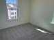 Minimalist bedroom with plush carpeting and ample natural light from a large window at 15088 Grove Lake Dr, Winter Garden, FL 34787