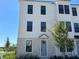 Charming three-story townhouse featuring light gray brickwork and a light gray front door at 15088 Grove Lake Dr, Winter Garden, FL 34787