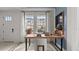 Modern office with a wood desk, chair, and large windows offering natural light at 15113 Grove Lake Dr, Winter Garden, FL 34787