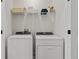 Bright laundry room with modern washer and dryer units and convenient shelving for storage solutions at 15113 Grove Lake Dr, Winter Garden, FL 34787