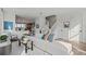Bright living room showcasing an open floor plan with stairs and an adjacent kitchen with bar-style seating at 15113 Grove Lake Dr, Winter Garden, FL 34787