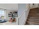 Modern staircase with wooden steps and views of a cozy chair and built-in bookshelves at 15113 Grove Lake Dr, Winter Garden, FL 34787