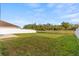 Backyard with green grass and a scenic lake view, enclosed by a white fence for privacy at 3189 Kearns Rd, Mulberry, FL 33860