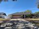 Home exterior featuring a grey roof, stone chimney, and beautiful curb appeal at 1000 Andrea Ridge Ct, Kissimmee, FL 34747