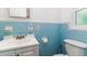 Clean bathroom featuring a toilet and single sink vanity with blue tile surround at 824 Interlake Dr, Lakeland, FL 33801