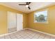 Bedroom featuring a ceiling fan, tile floors, and access to a private bathroom at 824 Interlake Dr, Lakeland, FL 33801