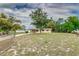 A large front yard surrounds this cozy home with a carport and chain-link fence at 824 Interlake Dr, Lakeland, FL 33801