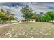 Landscape view of the front yard, fence, and home with attached carport at 824 Interlake Dr, Lakeland, FL 33801