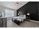 Modern bedroom with a black accent wall, neutral decor, and plenty of natural light, creating a cozy retreat at 5012 Laguna Bay Cir # 72, Kissimmee, FL 34746