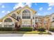 Condominium exterior featuring large windows, brick columns, and manicured landscaping, creating an inviting entrance at 5012 Laguna Bay Cir # 72, Kissimmee, FL 34746