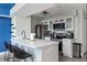Modern kitchen featuring white cabinetry, stainless steel appliances, quartz countertop, and a stylish island with seating at 5012 Laguna Bay Cir # 72, Kissimmee, FL 34746