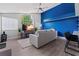 Cozy living room featuring a comfy sofa, a modern TV setup, and a stylish blue accent wall at 5012 Laguna Bay Cir # 72, Kissimmee, FL 34746