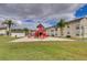 Community playground with slides, set in a sandy area and surrounded by green space and trees at 5012 Laguna Bay Cir # 72, Kissimmee, FL 34746