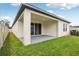 Exterior view of the home featuring a covered patio and a lush, green backyard at 6057 Sacred Oak Ave, Mount Dora, FL 32757