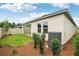 Back of house with manicured landscaping, green grass and neutral paint at 6057 Sacred Oak Ave, Mount Dora, FL 32757