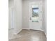 Bright foyer featuring a front door with glass and neutral walls that lead to a tiled floor at 6057 Sacred Oak Ave, Mount Dora, FL 32757