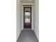 Stylish front door with glass panel and dark trim, set against a neutral interior wall at 6057 Sacred Oak Ave, Mount Dora, FL 32757