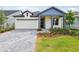 Charming single-story home with a beautifully landscaped front yard and a brick driveway at 6057 Sacred Oak Ave, Mount Dora, FL 32757