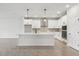 Spacious kitchen featuring white cabinetry, stainless steel appliances, and a central island at 6057 Sacred Oak Ave, Mount Dora, FL 32757