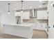Well-lit kitchen with stainless steel range hood, white cabinets, and central island at 6057 Sacred Oak Ave, Mount Dora, FL 32757