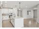 Modern kitchen boasts a large island, stylish pendant lighting, and sleek, white cabinetry at 6057 Sacred Oak Ave, Mount Dora, FL 32757