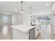 Bright kitchen featuring an island with stainless steel appliances and access to the backyard at 6057 Sacred Oak Ave, Mount Dora, FL 32757