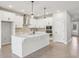 Modern kitchen boasts white cabinets, stainless steel appliances, and a stylish central island at 6057 Sacred Oak Ave, Mount Dora, FL 32757