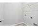 This functional laundry room features a wire shelf and tile flooring at 6057 Sacred Oak Ave, Mount Dora, FL 32757