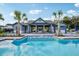 Community pool area with a splash pad, lounge chairs, and beautiful landscaping at 6057 Sacred Oak Ave, Mount Dora, FL 32757