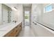 Bright bathroom with walk-in shower, double vanity with quartz countertop, and access to bedroom at 6221 Trailblaze Bnd, St Cloud, FL 34771