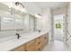 Bathroom featuring a large mirror over a double vanity and a glimpse into an adjoining room at 6221 Trailblaze Bnd, St Cloud, FL 34771