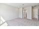 A well-lit bedroom features neutral walls, gray carpeting, and doorways to an ensuite bathroom and closet at 6221 Trailblaze Bnd, St Cloud, FL 34771