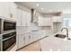 Modern kitchen with stainless steel appliances, white cabinets and quartz countertops, offering great efficiency at 6221 Trailblaze Bnd, St Cloud, FL 34771