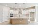Modern kitchen with white cabinets, stainless steel appliances, an island, and stylish pendant lighting at 6221 Trailblaze Bnd, St Cloud, FL 34771