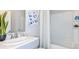 Bright bathroom featuring a tub with white tiling, modern fixtures, and an elegant white countertop basin at 7347 Capstone Dr, Groveland, FL 34736