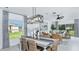 Dining area open to living room featuring modern lighting and large windows overlooking the backyard at 7347 Capstone Dr, Groveland, FL 34736