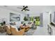 Bright living room with white sectional, modern decor, ceiling fan, and a view of the landscaped backyard at 7347 Capstone Dr, Groveland, FL 34736
